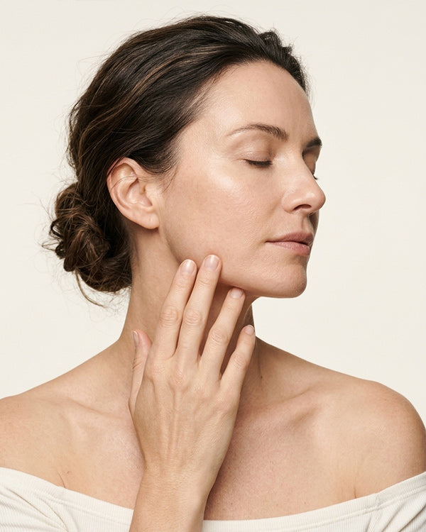  Woman pressing castor oil into her jaw and neck with her fingertips