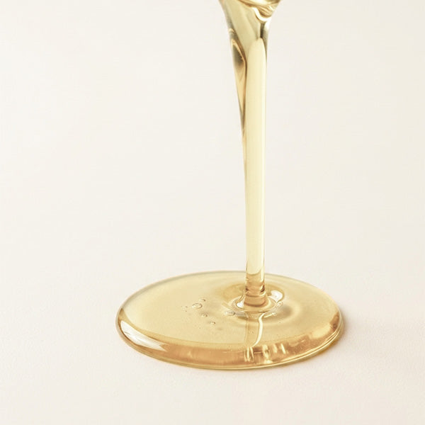 Cold pressed castor oil pouring in a clear golden stream, unrefined and additive free
